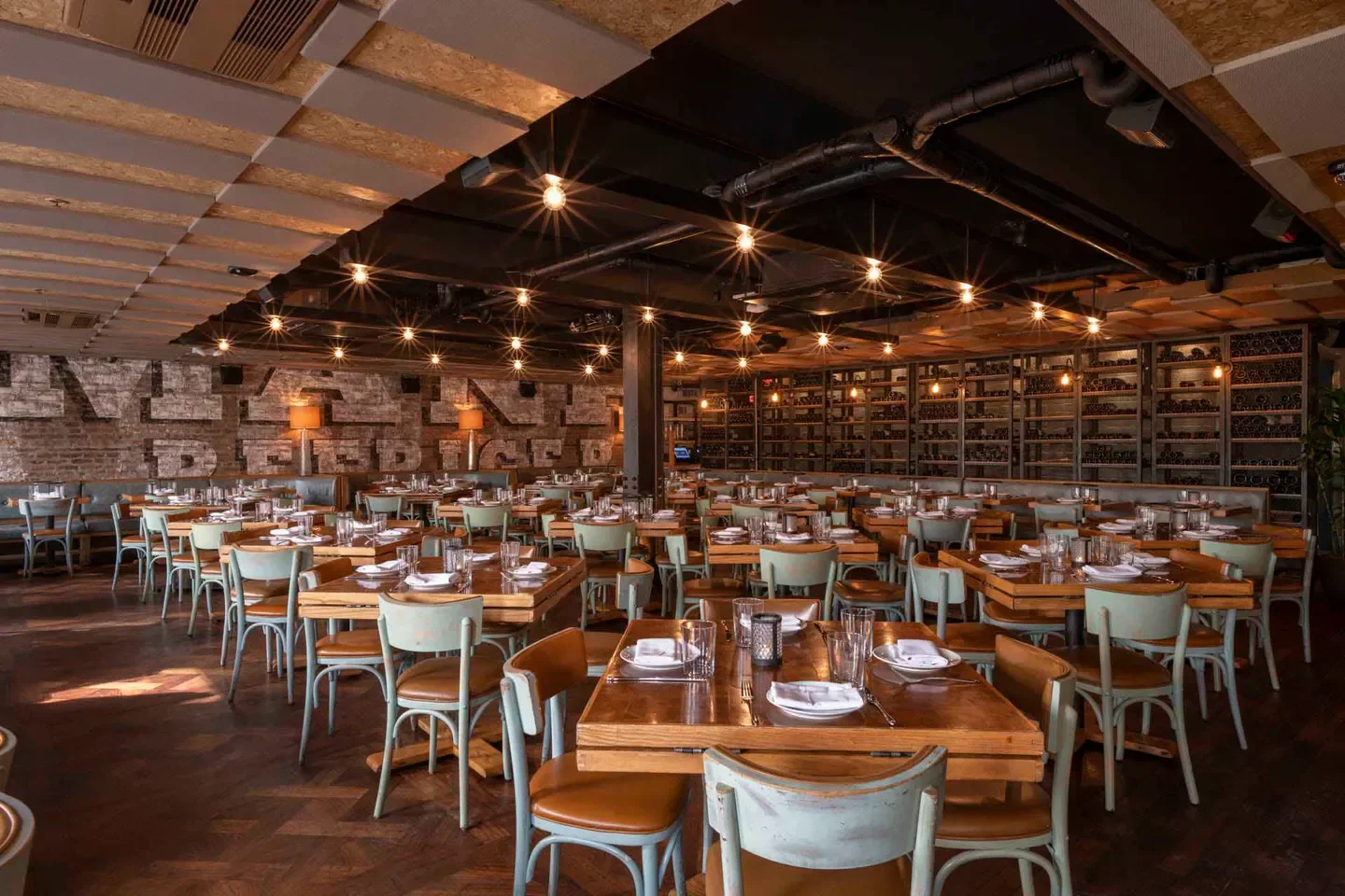 Interior dining area at Catch restaurant in New York City with wooden tables and chairs.
