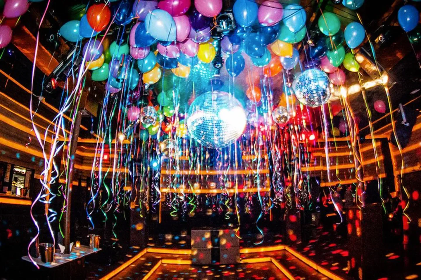 Festive interior of Cielo nightclub in New York City with disco balls and balloons.