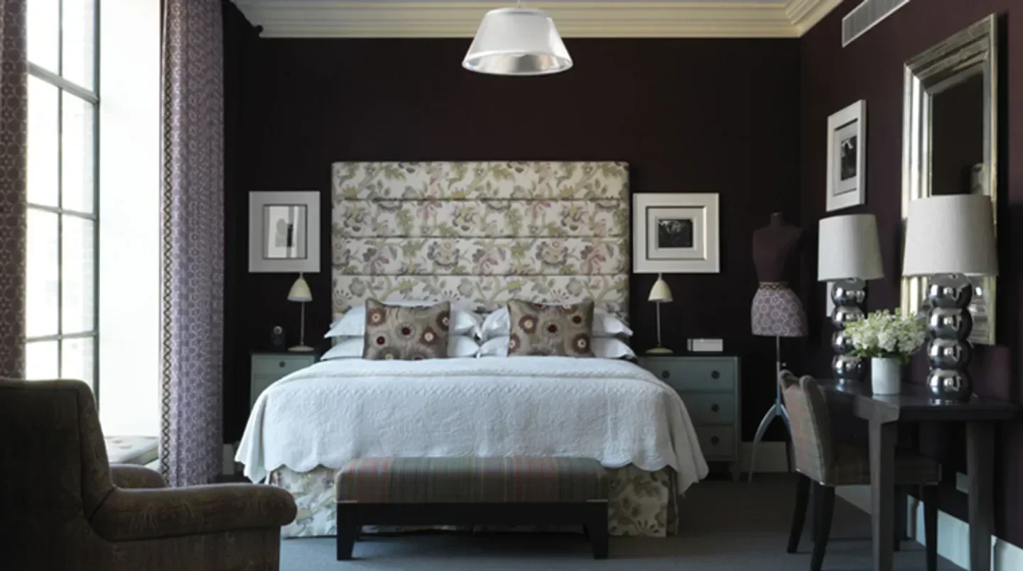 Cozy bedroom at Crosby Street Hotel in New York City with floral headboard and decor.