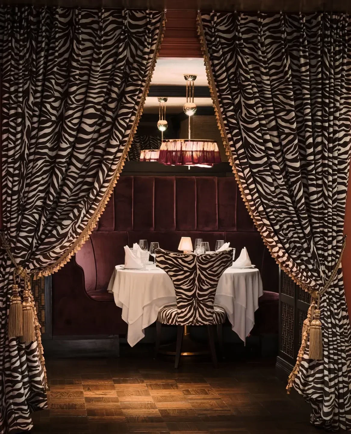 Zebra print chair at Dirty French restaurant in New York City with elegant curtains.