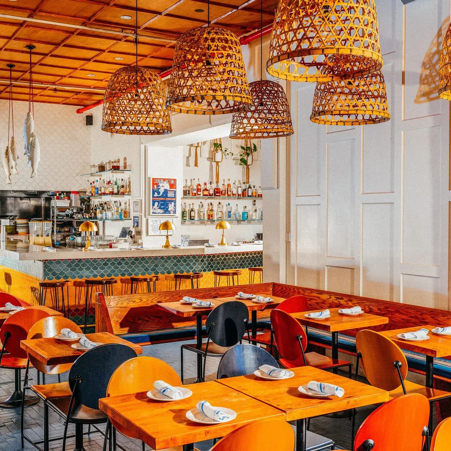 Interior of Fish Cheeks in New York City features bamboo lamps and dining tables.