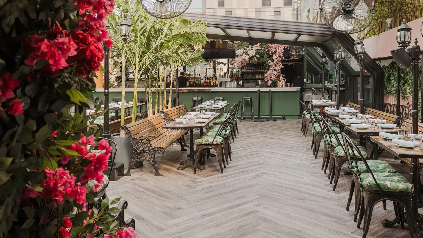 Outdoor dining area at Hotel Chantelle restaurant in New York City with floral decor.