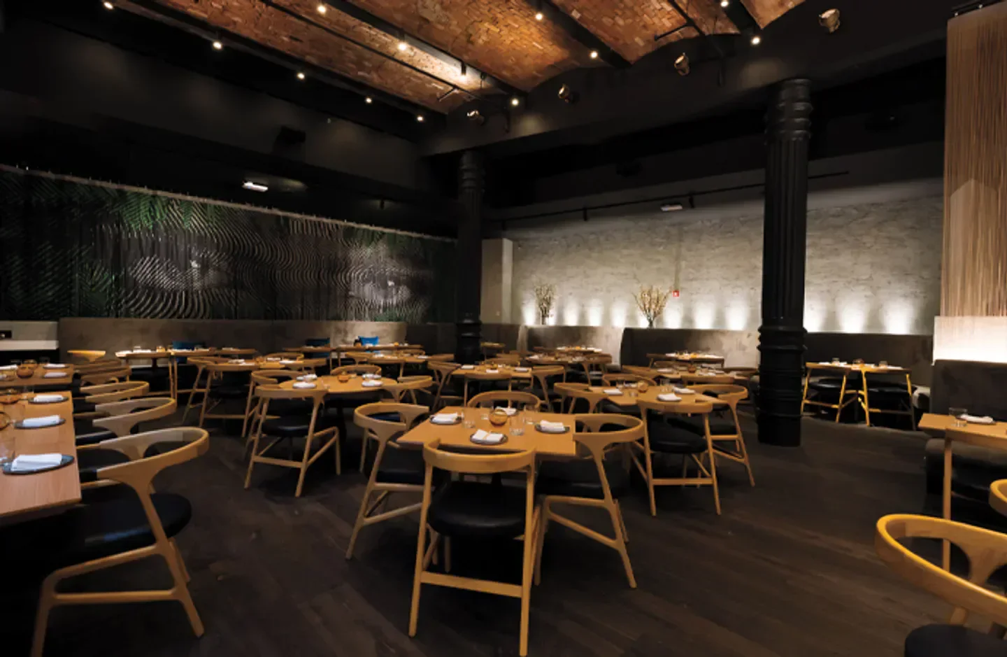 Cozy dining area at KYU New York City, featuring stylish wooden tables and chairs.