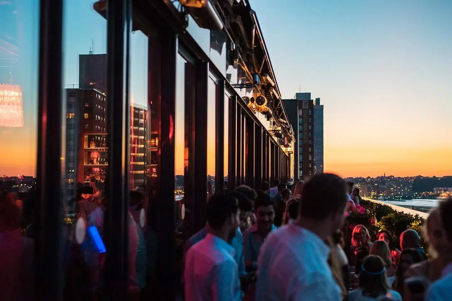 Sunset view from PHD Rooftop in New York City with a crowd enjoying the atmosphere.