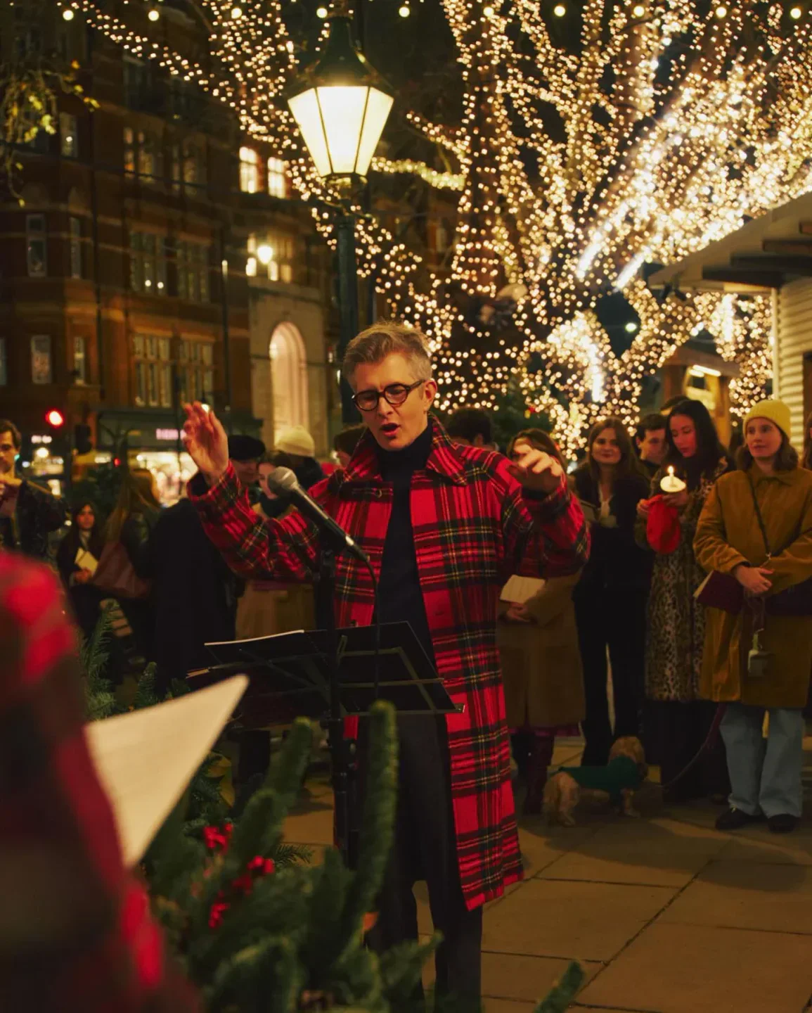 Festive scene outside Polo Bar in New York City with holiday lights and a performance.