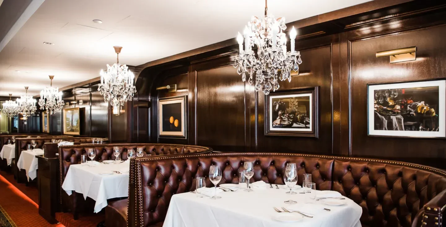 Elegant dining room at Rare Steakhouse in New York City with crystal chandeliers.