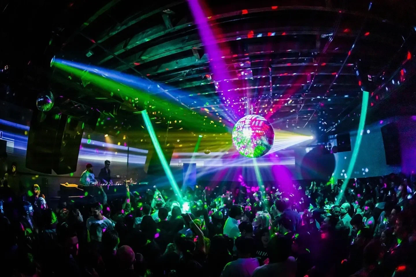 Dance floor at Schimanski nightclub in New York City with colorful lights and crowd.