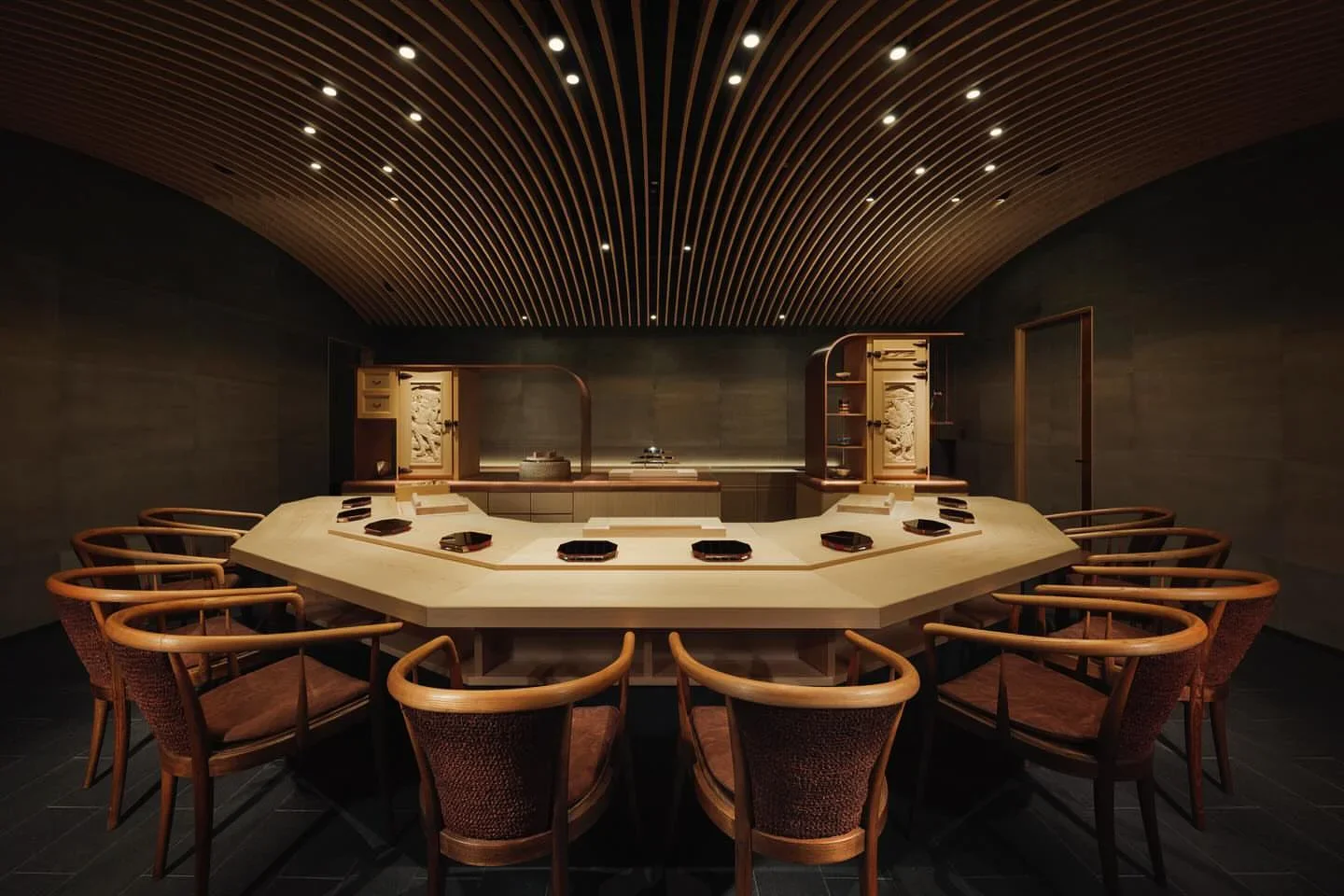 Sushi Sho restaurant interior in the city features elegant wooden seating and a contemporary U-shaped sushi bar.
