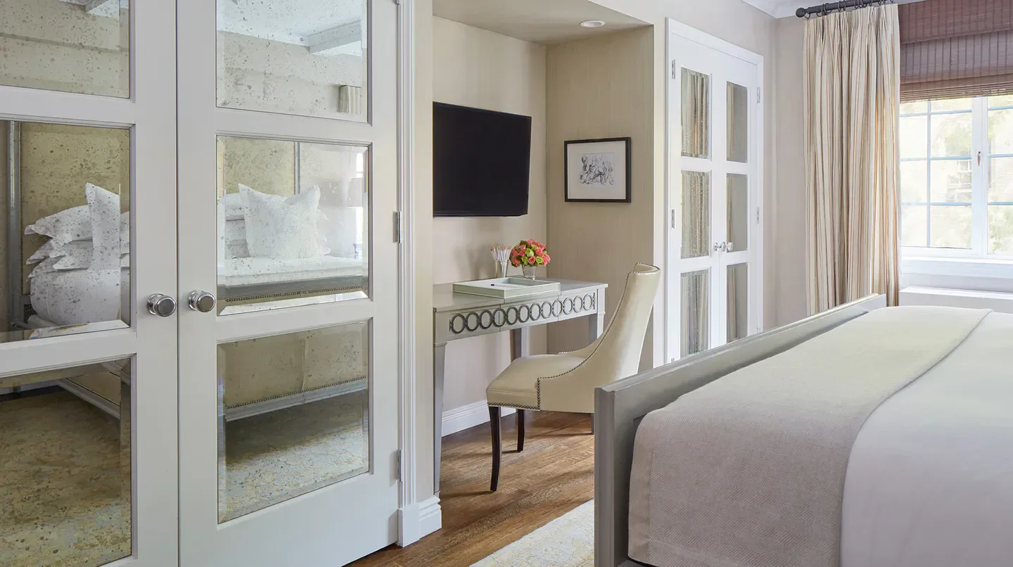 Elegant bedroom at The Lowell hotel in New York City with mirrored doors and desk.