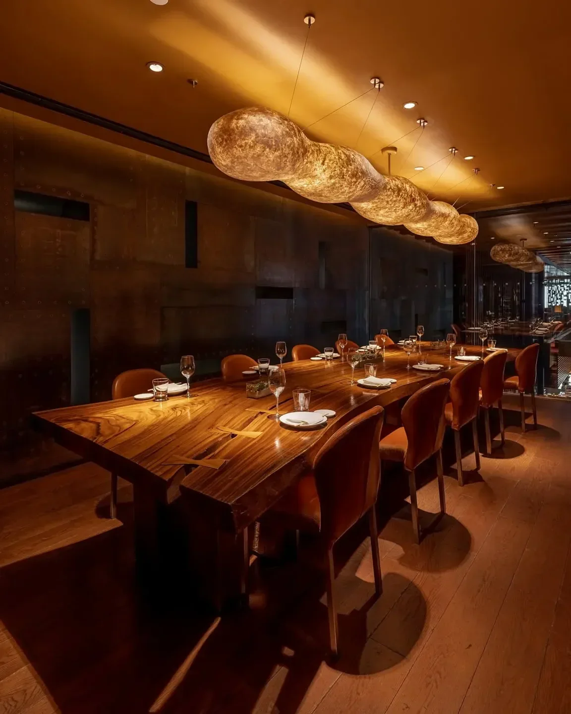 Elegant dining at Zuma restaurant, showcasing a long wooden table in New York City.